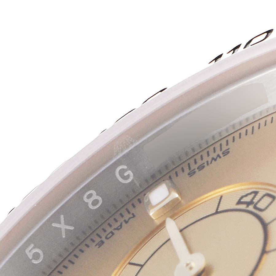 The image shows a close-up angle of the Rolex Daytona 116503 Men's Steel and Gold (two tone) Champagne Dial 116503 Men's Steel and Gold (two tone) Champagne Dial watch, highlighting the bezel, part of the dial, and an index marker.