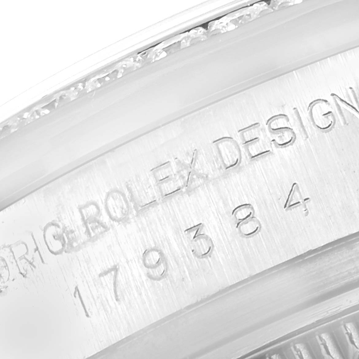 The image shows a close-up of the side engraving on a Rolex Datejust 179384 Women's Stainless Steel Pink Dial 179384 Women's Stainless Steel Pink Dial watch, displaying its design and serial numbers.