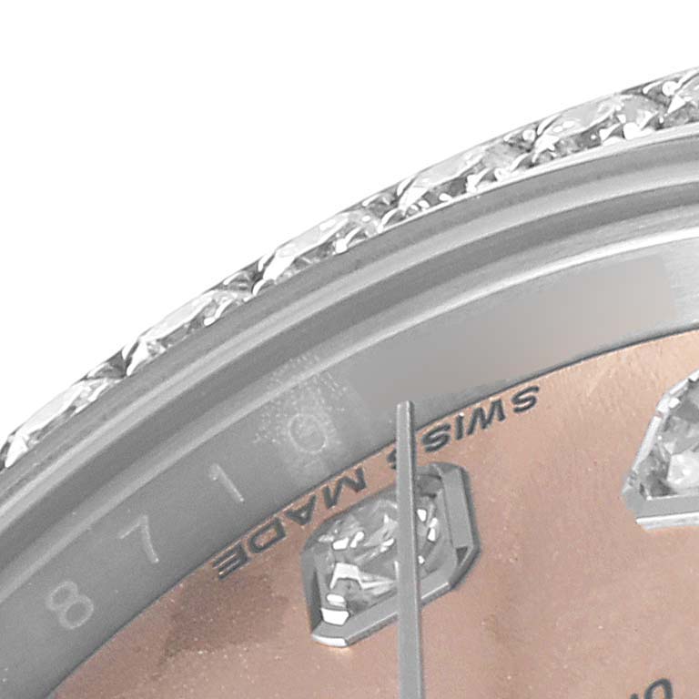 This close-up of the Rolex Datejust 179384 Women's Stainless Steel Pink Dial 179384 Women's Stainless Steel Pink Dial watch shows part of the bezel, dial, hour markers, and minute hand.