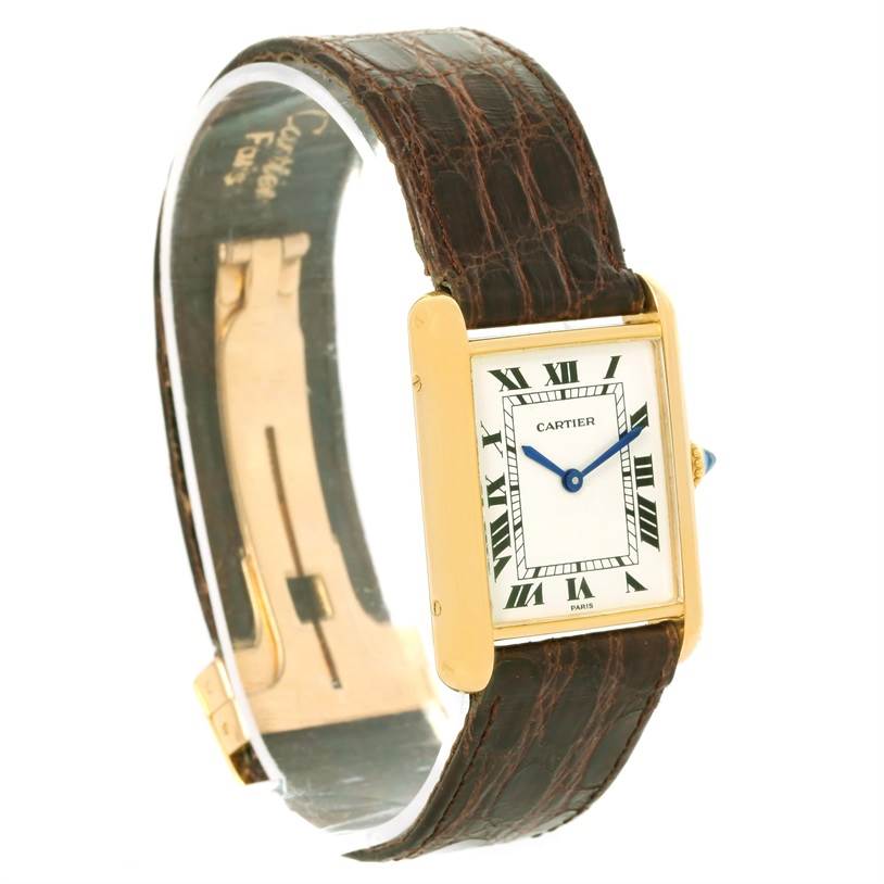 This image features a Cartier Tank Classic Men's Yellow Gold White Dial Men's Yellow Gold White Dial watch at a slight angle, displaying its rectangular face, brown leather strap, and gold case.