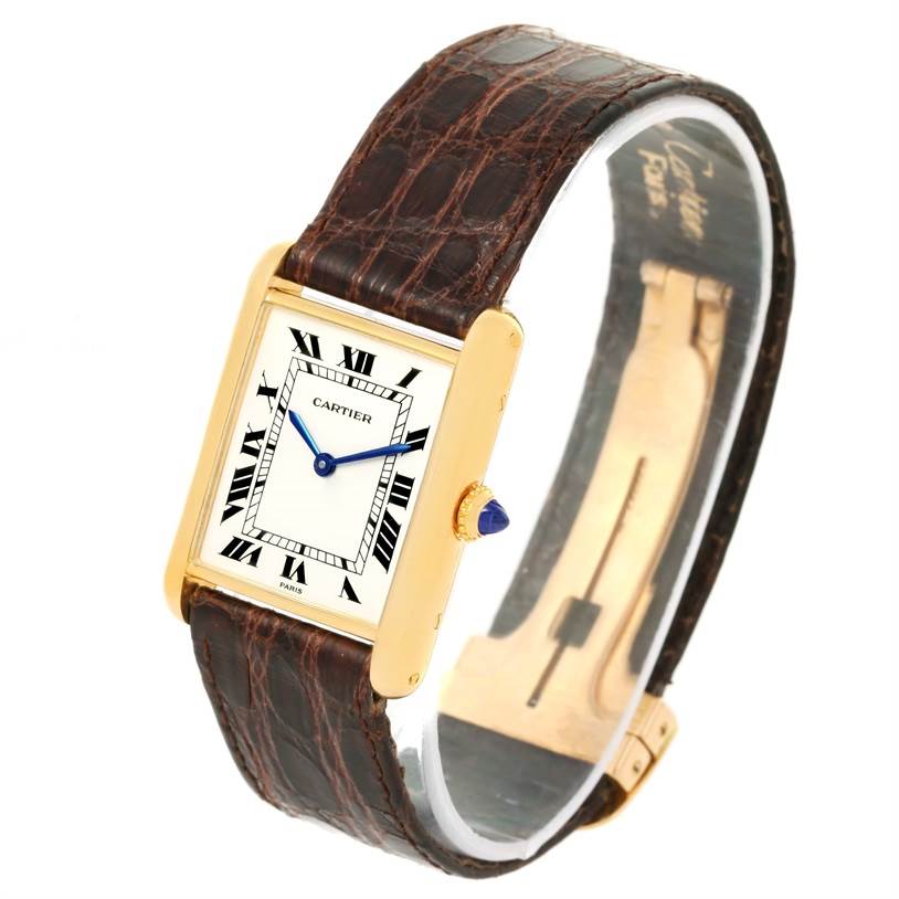 The Cartier Tank Classic Men's Yellow Gold White Dial Men's Yellow Gold White Dial watch is shown at an angled view, displaying the face, leather strap, and part of the clasp.