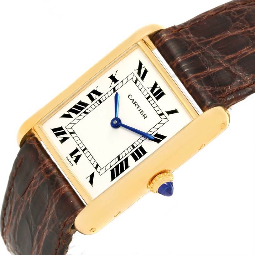 The Cartier Tank Classic Men's Yellow Gold White Dial Men's Yellow Gold White Dial watch is shown at a slight angle, highlighting its face, blue hands, crown with blue gem, and leather strap.