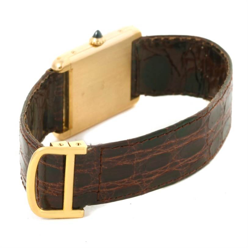 This image shows a side and back view of the Tank Classic model by Cartier, highlighting its leather strap and the side crown.