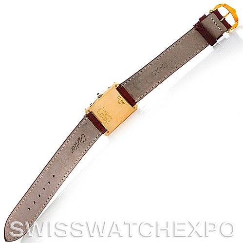 This image shows the underside of a Cartier Tank Classic Men's Yellow Gold Silver Dial Men's Yellow Gold Silver Dial watch, displaying the strap, buckle, and case back.