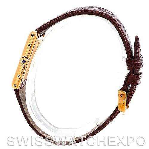 The Cartier Tank Classic Men's Yellow Gold Silver Dial Men's Yellow Gold Silver Dial watch is shown from a side angle, displaying the strap, buckle, and gold case with a blue cabochon crown.