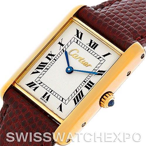 The image shows a Cartier Tank Classic Men's Yellow Gold Silver Dial Men's Yellow Gold Silver Dial watch at an angle, featuring its dial, Roman numerals, crown, and part of the leather strap.