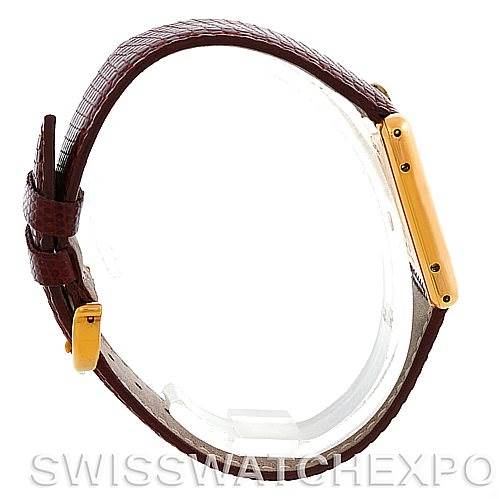 The image shows a side angle of the Cartier Tank Classic Men's Yellow Gold Silver Dial Men's Yellow Gold Silver Dial watch, displaying the brown leather strap and gold-tone case.