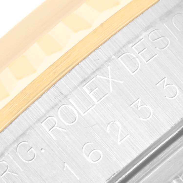 The image shows a close-up of the case side engraving and the gold fluted bezel of a Rolex Datejust 16233 Men's Steel and Gold (two tone) Champagne Dial 16233 Men's Steel and Gold (two tone) Champagne Dial watch.