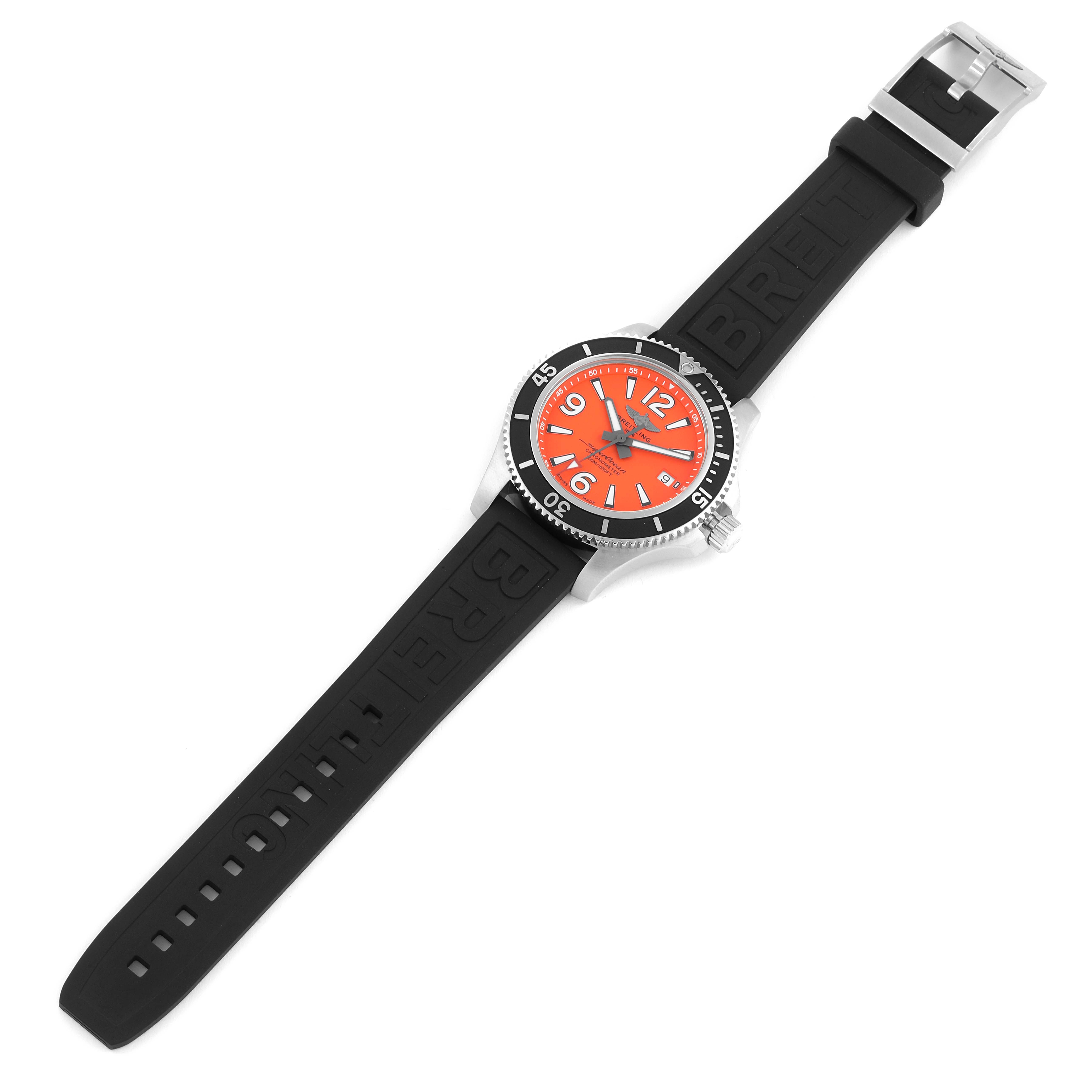 The image shows a Superocean model by Breitling from a top view, displaying the black strap, orange dial, and bezel.