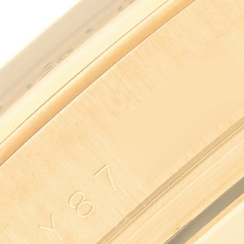 This close-up image shows the edge and engraved part of the bezel on a Rolex Daytona 116528 Men's Yellow Gold Black Dial 116528 Men's Yellow Gold Black Dial watch.