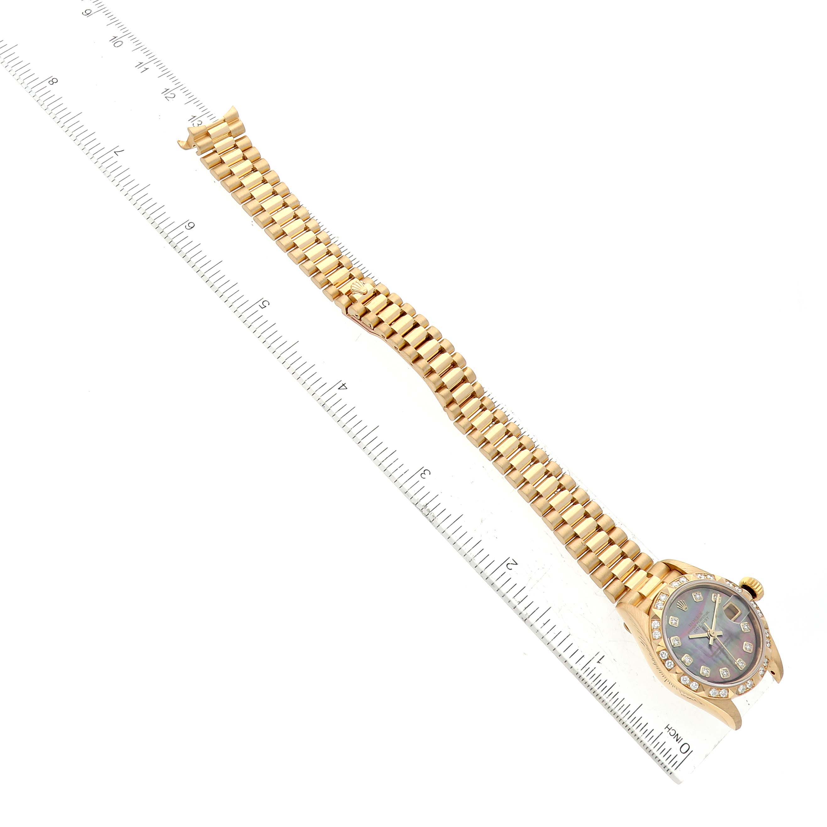 The image shows a Rolex President 79258 Women's Yellow Gold Mother of Pearl Dial 79258 Women's Yellow Gold Mother of Pearl Dial model watch laid flat with the full bracelet and face visible next to a ruler for scale.