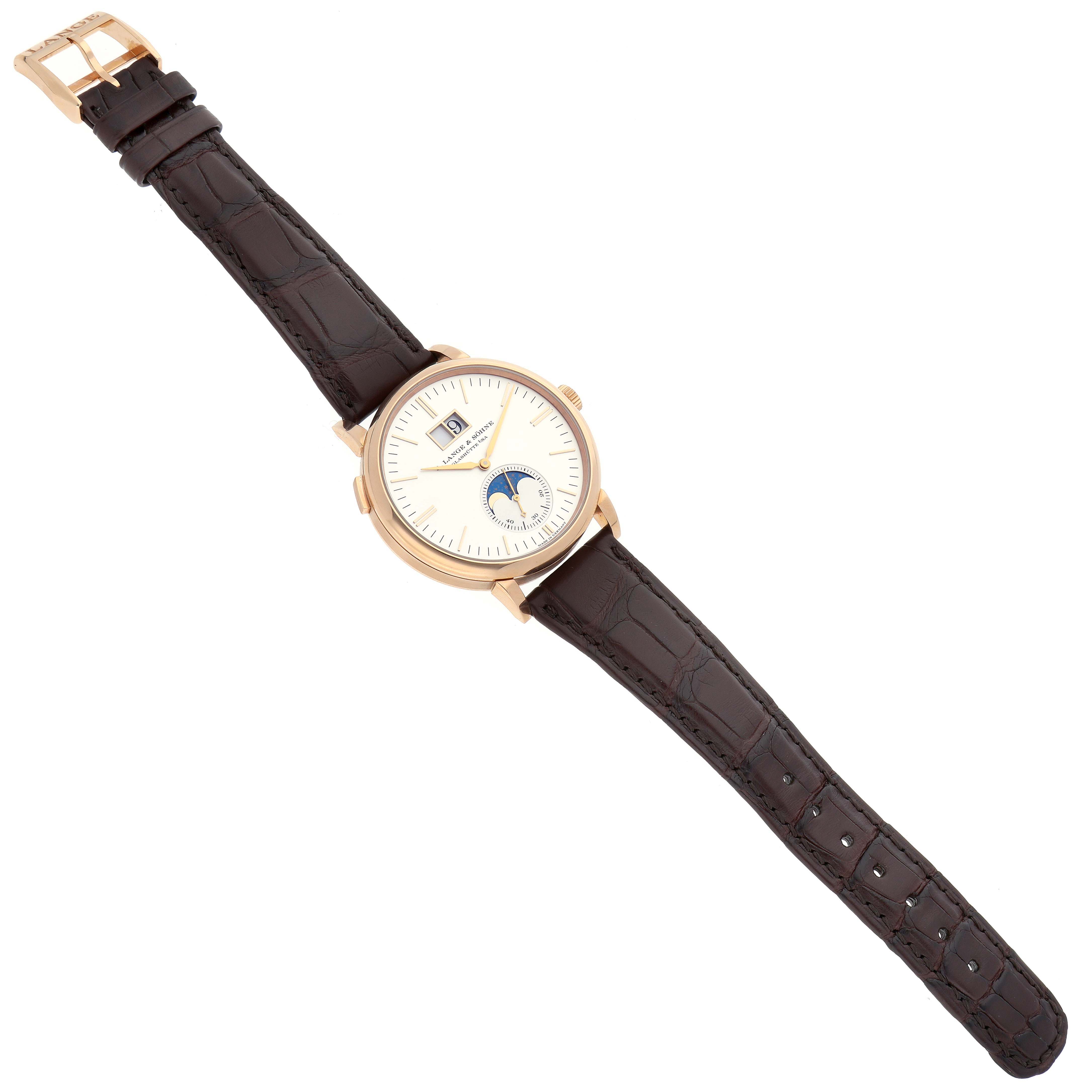 The A. Lange & Sohne Saxonia 384.032 Men's Rose Gold Silver Dial watch is shown from a top-down view, displaying the face, strap, and buckle.