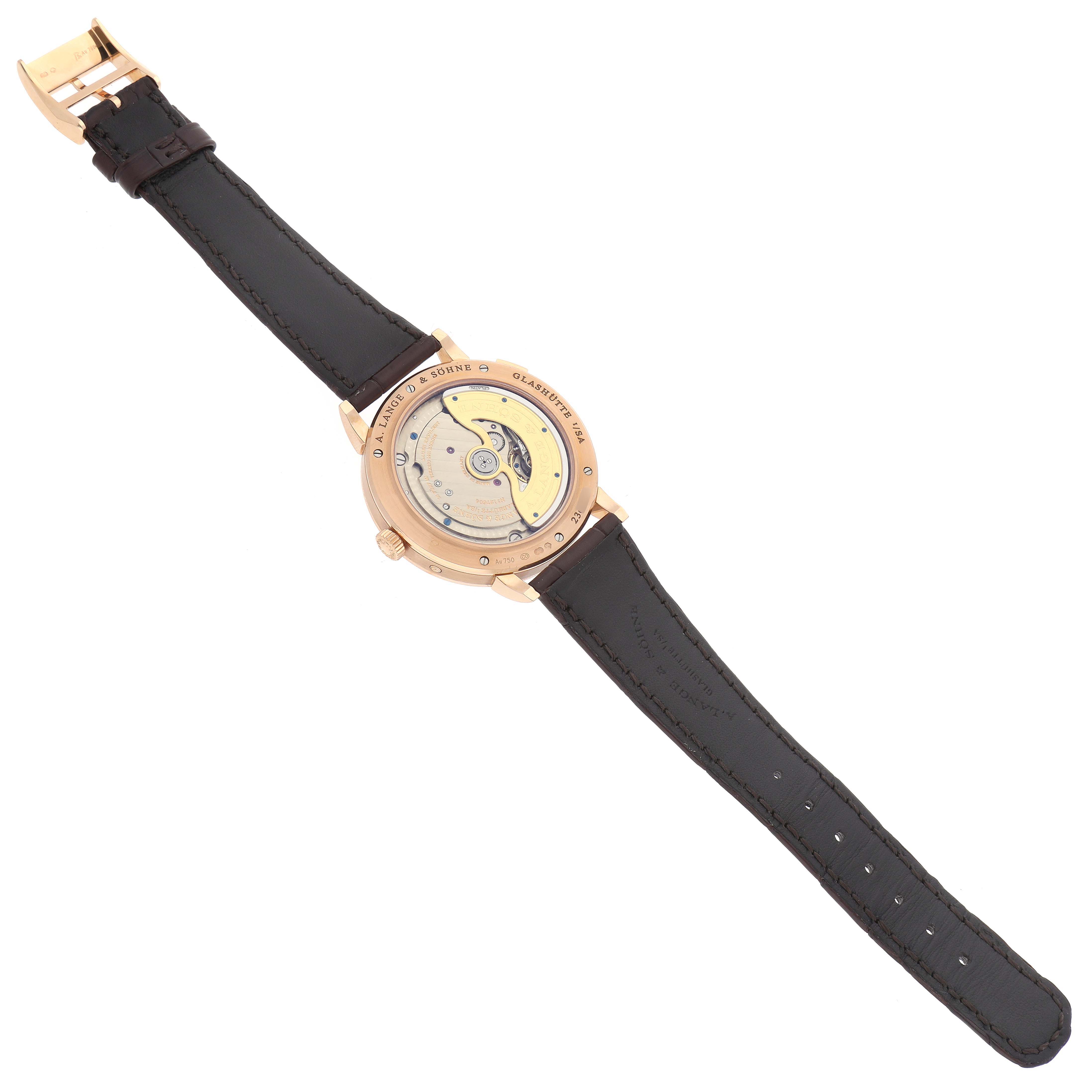 The image shows the back view of the A. Lange & Sohne Saxonia 384.032 Men's Rose Gold Silver Dial watch, showcasing its movement and strap.