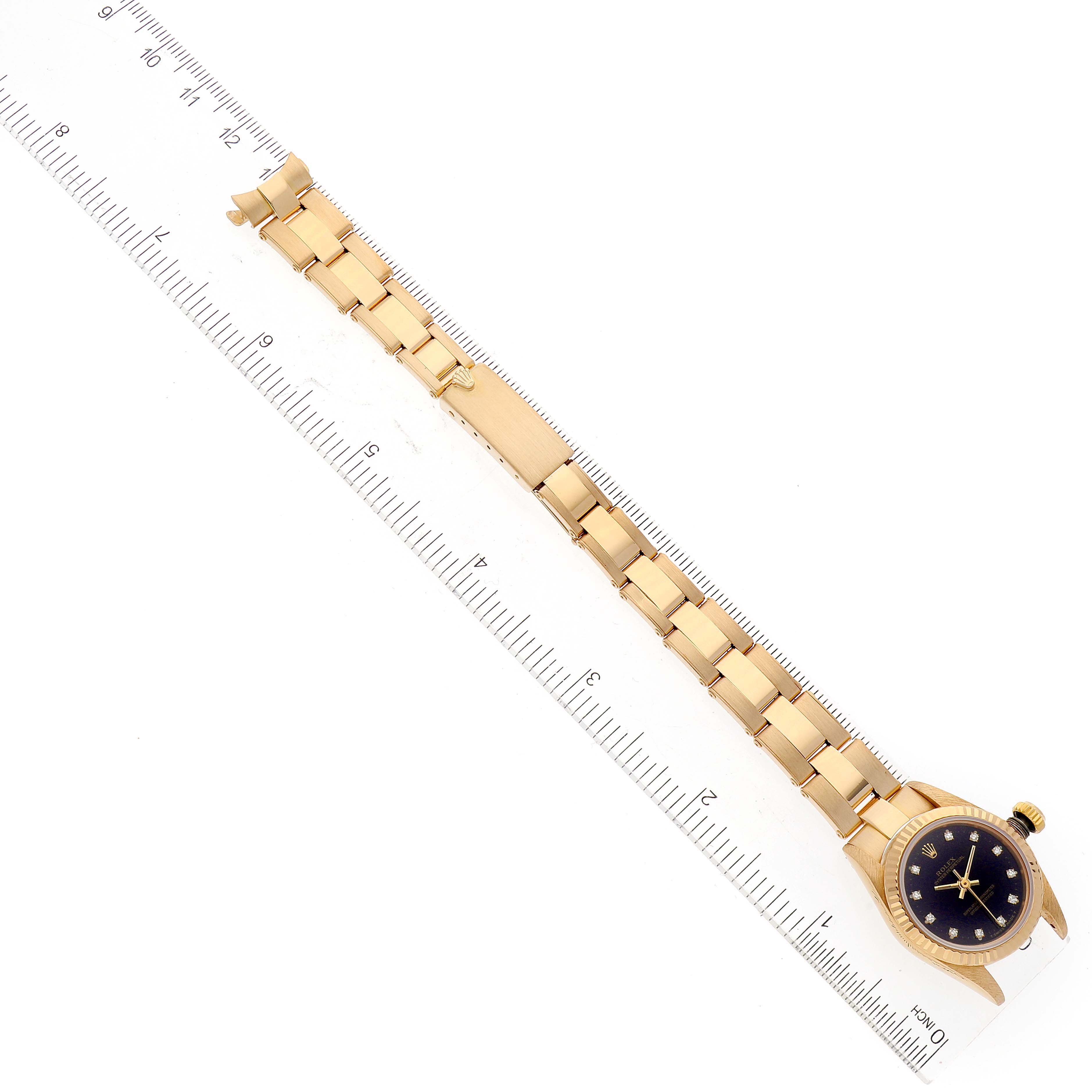 The image shows a Rolex Pearlmaster 67198 Women's Yellow Gold Black Dial 67198 Women's Yellow Gold Black Dial watch laid flat alongside a ruler, highlighting the bracelet and face from a top-down angle.