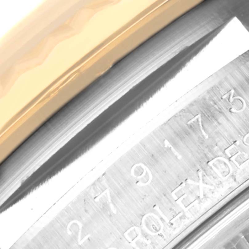 The image shows a close-up angle of the Rolex Datejust 279173 Women's Steel and Gold (two tone) Champagne Dial 279173 Women's Steel and Gold (two tone) Champagne Dial watch's engraved bezel and the edge of the watch case.