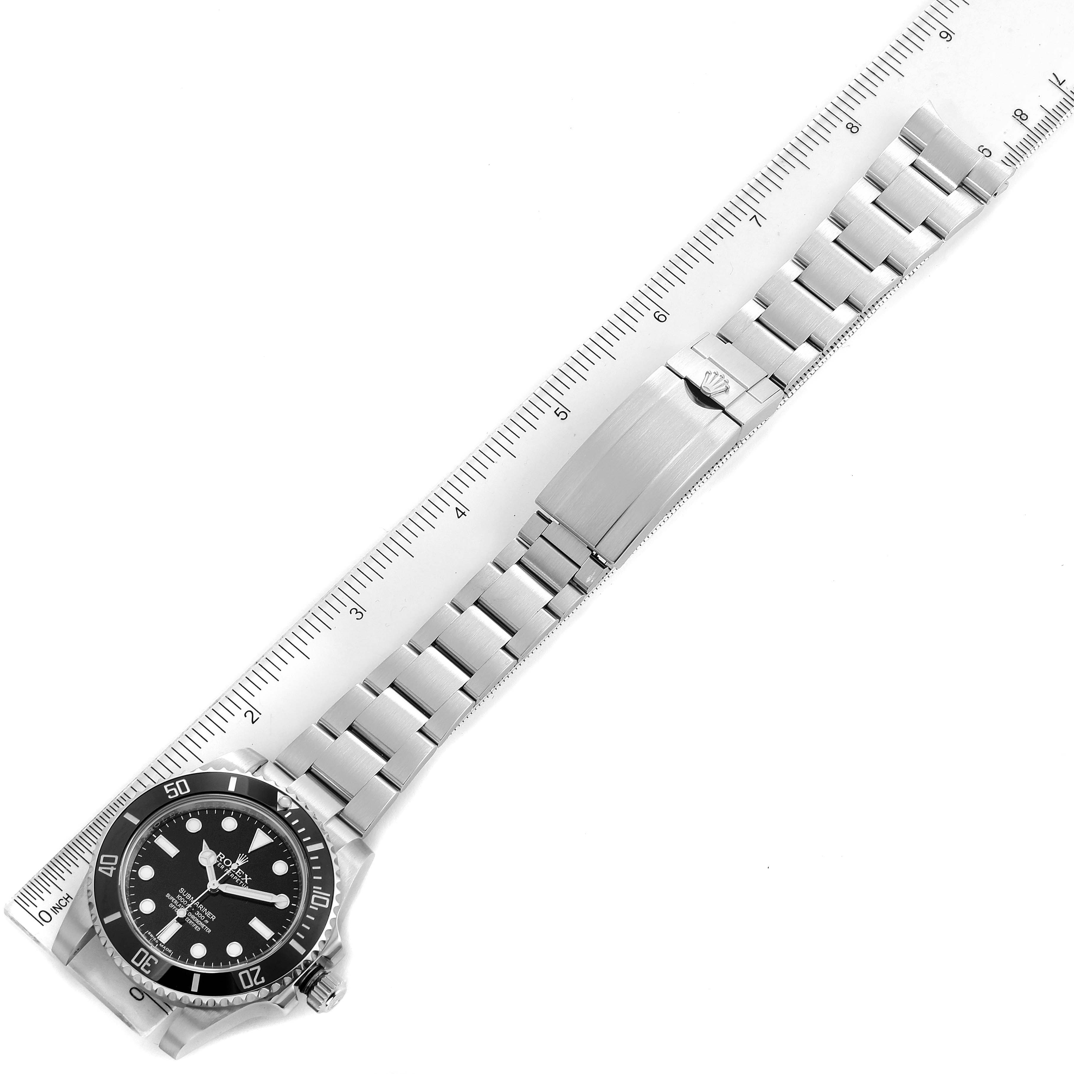 The image shows a top-down view of a Rolex Submariner 114060 Men's Stainless Steel Black Dial 114060 Men's Stainless Steel Black Dial watch with a metal bracelet placed alongside a ruler.