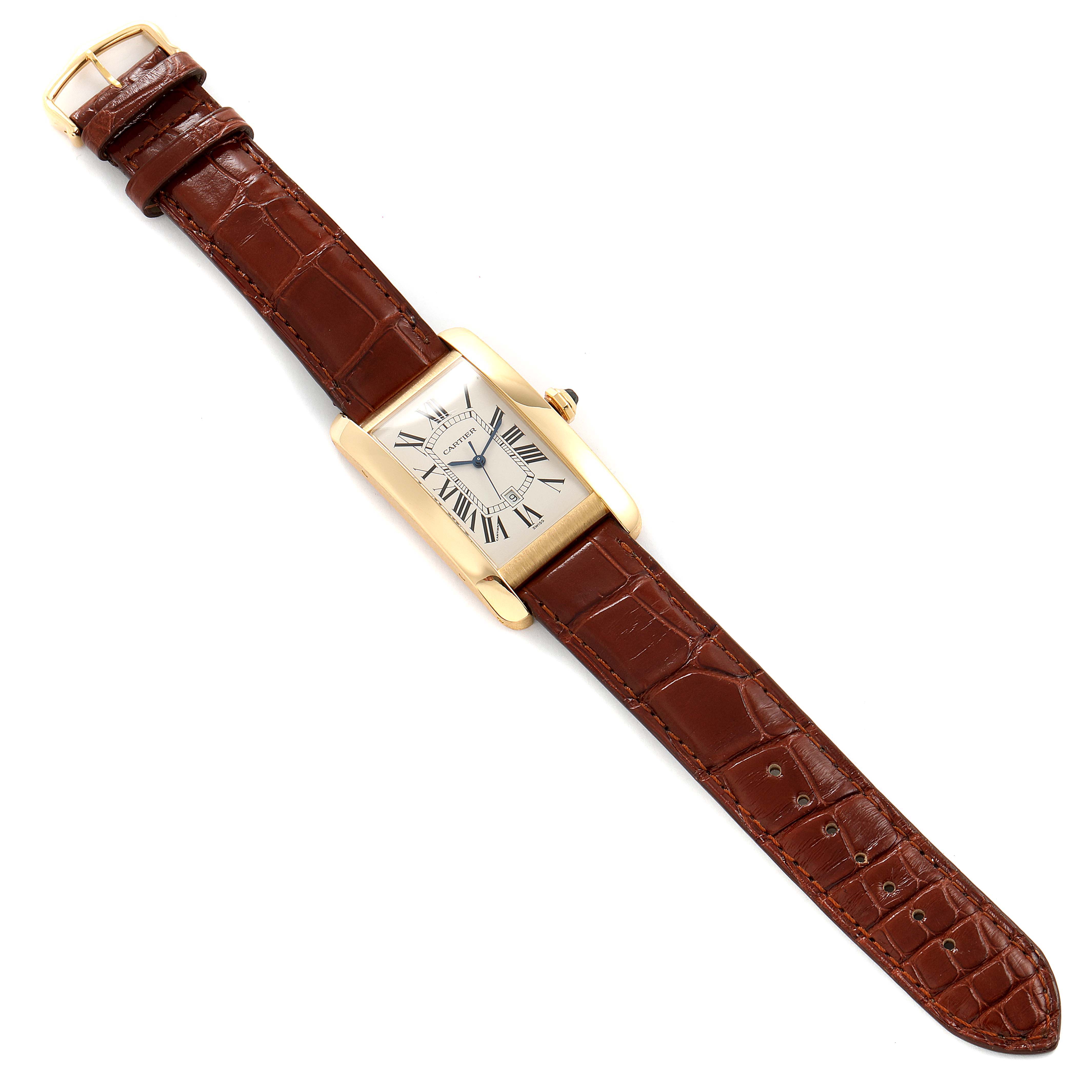 The Cartier Tank Americaine W2603156 Men's Yellow Gold Silver Dial W2603156 Men's Yellow Gold Silver Dial watch is shown laid flat, displaying its rectangular face and brown leather strap.