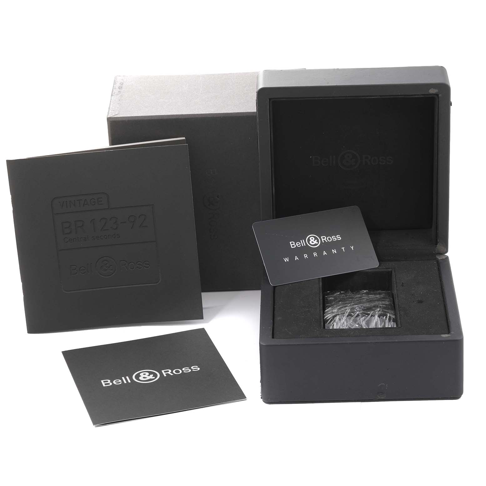 The image shows the box, a warranty card, and documents for the Bell & Ross Heritage BR 123-92-SP Men's Stainless Steel Black Dial BR 123-92-SP Men's Stainless Steel Black Dial model watch.