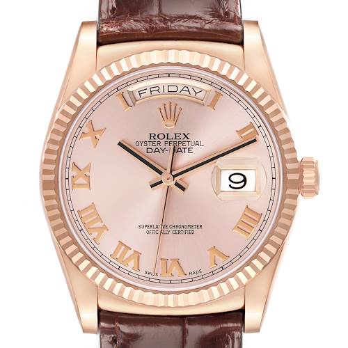 The Rolex President model 118135 is shown from a frontal angle, highlighting the dial, fluted bezel, day-date display, and brown leather strap.