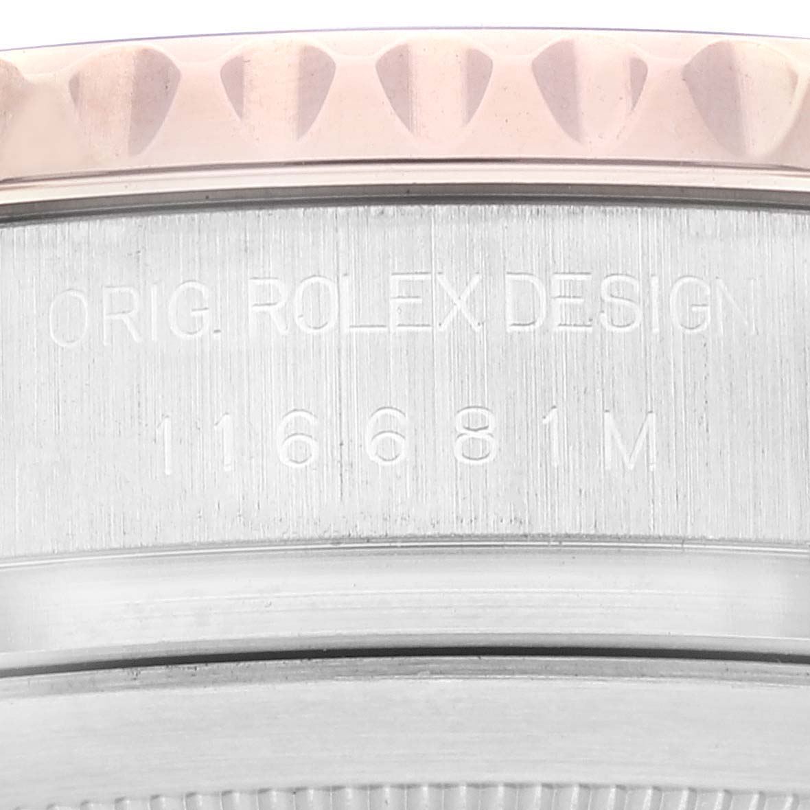The image shows a close-up of the edge of the bezel and case back of the Rolex Yacht-Master 116681 Men's Steel and Gold (two tone) White Dial 116681 Men's Steel and Gold (two tone) White Dial model, highlighting the engraved serial number and "Orig. Rolex Design."