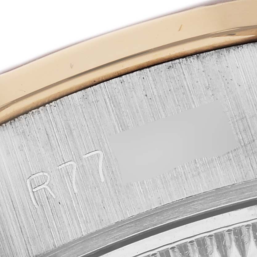 This close-up view of the Rolex President 69149 Women's White Gold Champagne Dial 69149 Women's White Gold Champagne Dial watch shows a portion of its bezel and engraved serial number.