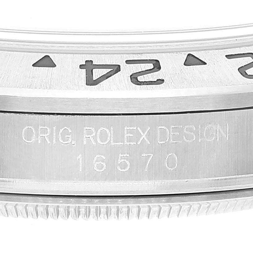 The image shows a close-up of the bezel and case side of the Rolex Explorer 16570 Men's Stainless Steel White Dial 16570 Men's Stainless Steel White Dial model, highlighting the engraved text "ORIG. ROLEX DESIGN 16570".