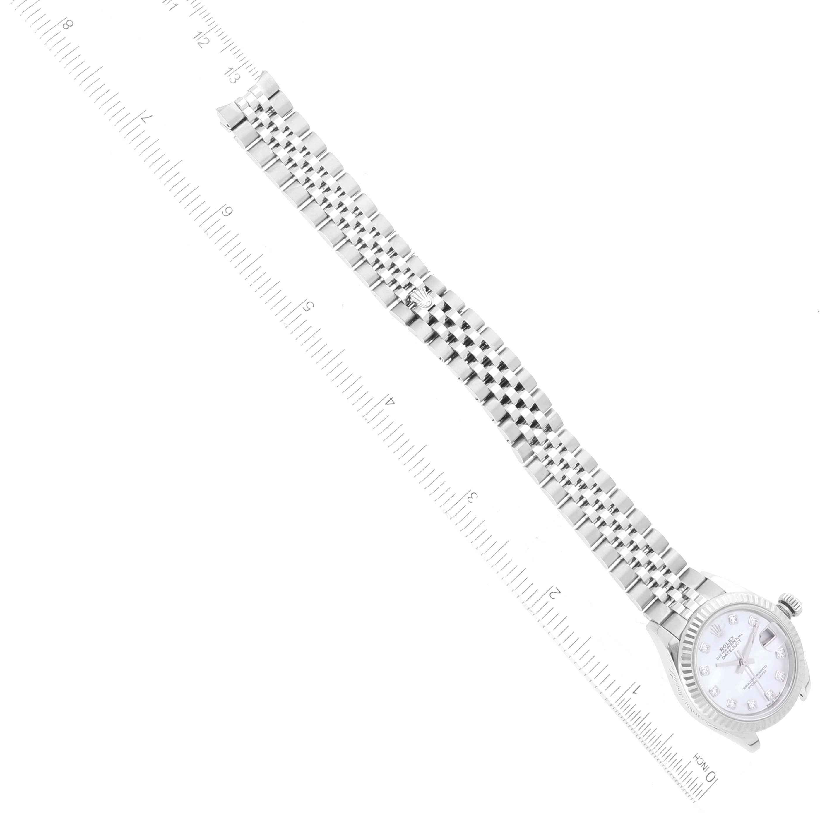 This image shows a Rolex Datejust 279174 Women's Stainless Steel Mother of Pearl Dial 279174 Women's Stainless Steel Mother of Pearl Dial watch laid out flat beside a ruler, displaying its face and bracelet.