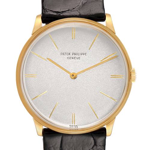 The image shows the face of a Vintage Patek Philippe watch, with a gold case, white dial, and black leather strap, viewed from the front.