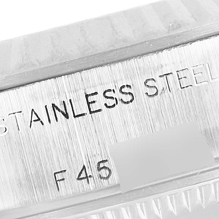 This close-up image shows the engraved "STAINLESS STEEL" text on the case of a Rolex Datejust 79174 Women's Stainless Steel Mother of Pearl Dial 79174 Women's Stainless Steel Mother of Pearl Dial watch.