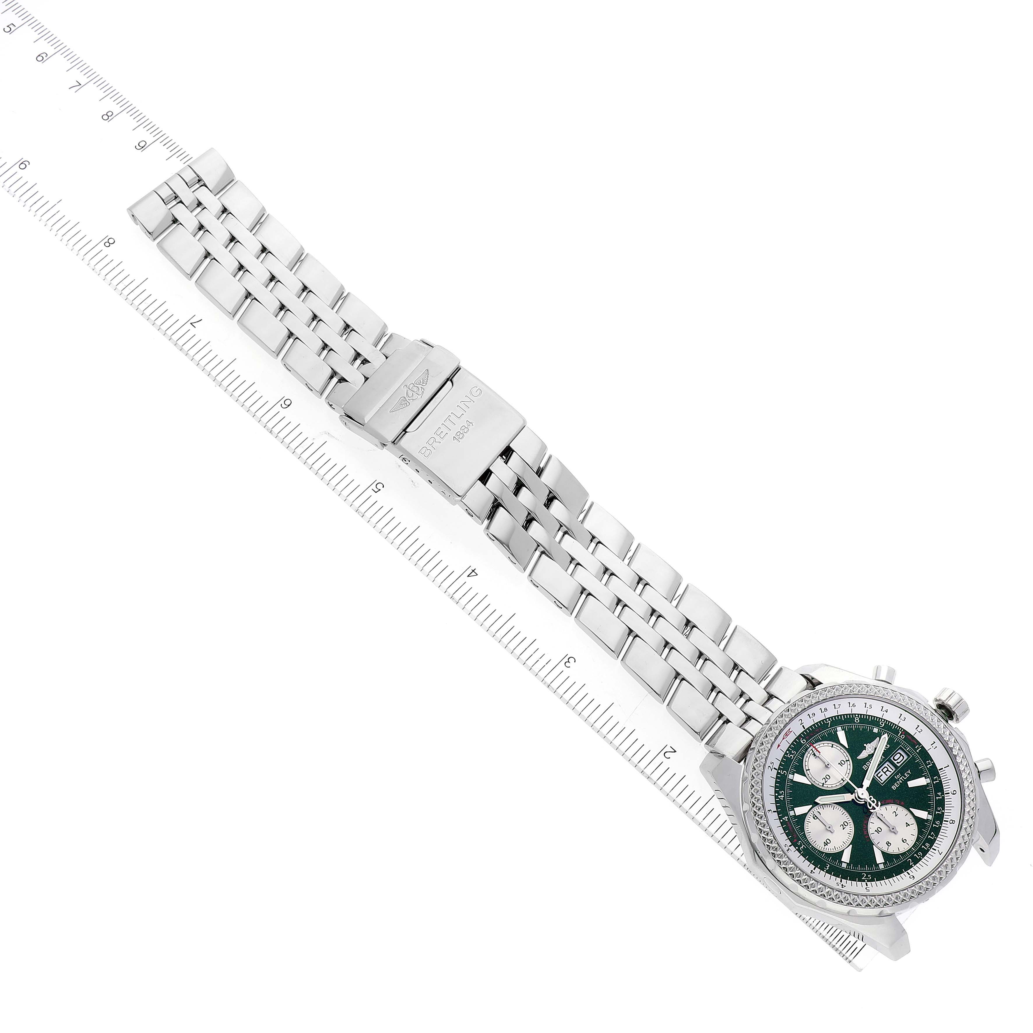The image shows a Breitling Bentley A13362 Men's Stainless Steel Green Dial A13362 Men's Stainless Steel Green Dial watch with a metal bracelet and clasp, laid diagonally alongside a ruler.