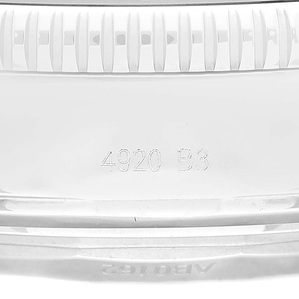 The image shows a close-up view of the side of a Breitling Superocean AB0162 Men's Stainless Steel Silver Dial AB0162 Men's Stainless Steel Silver Dial watch, specifically focusing on the engraved serial number and the bezel.