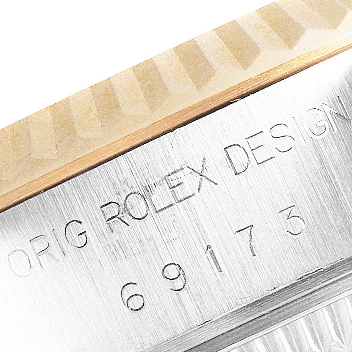This image shows a close-up of the bezel and engraved serial number of a Rolex Datejust 69173 Women's Steel and Gold (two tone) White Dial 69173 Women's Steel and Gold (two tone) White Dial watch.