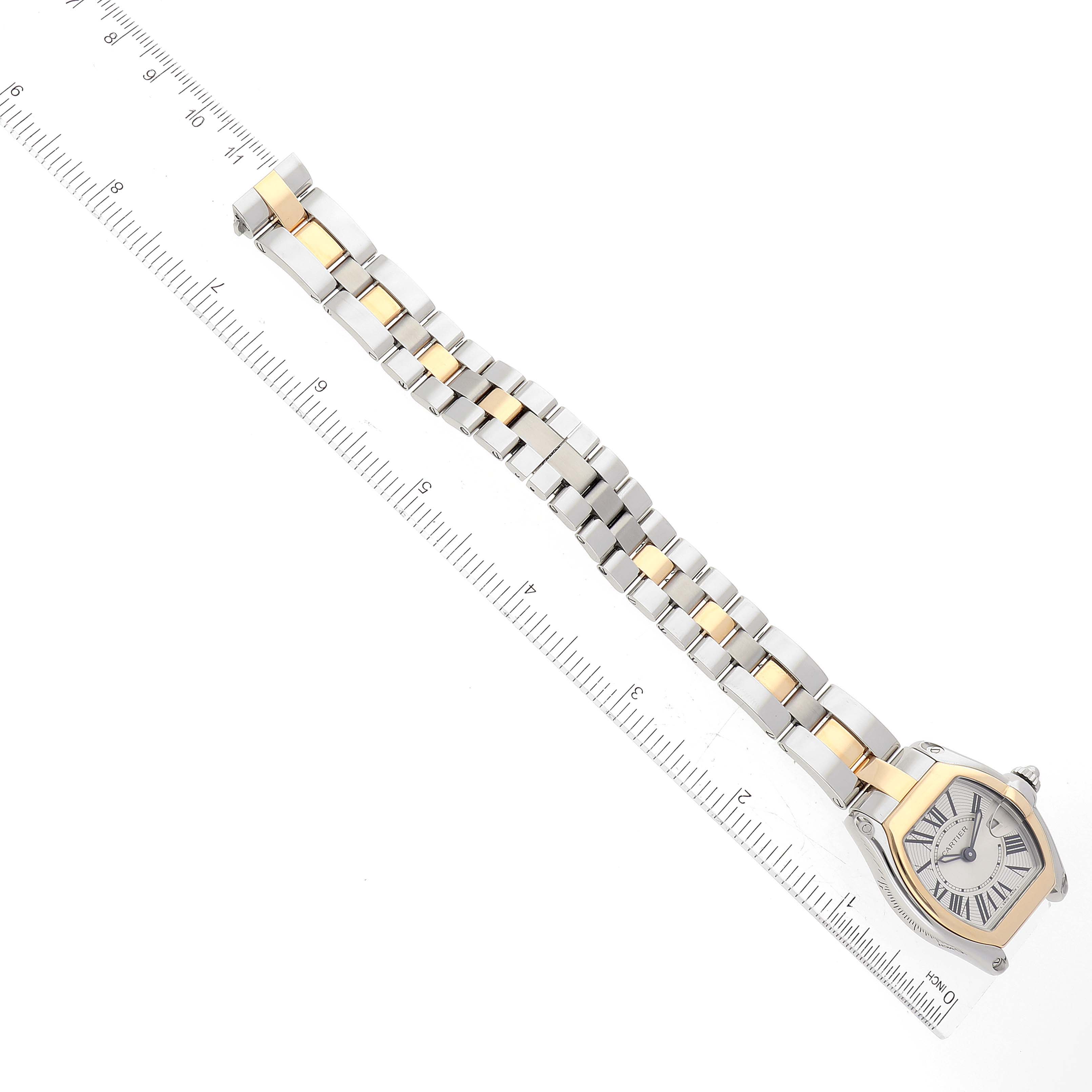 The image shows a Cartier Roadster W62026Y4 Women's Steel and Gold (two tone) Silver Dial W62026Y4 Women's Steel and Gold (two tone) Silver Dial watch laid flat with a ruler next to it for scale.
