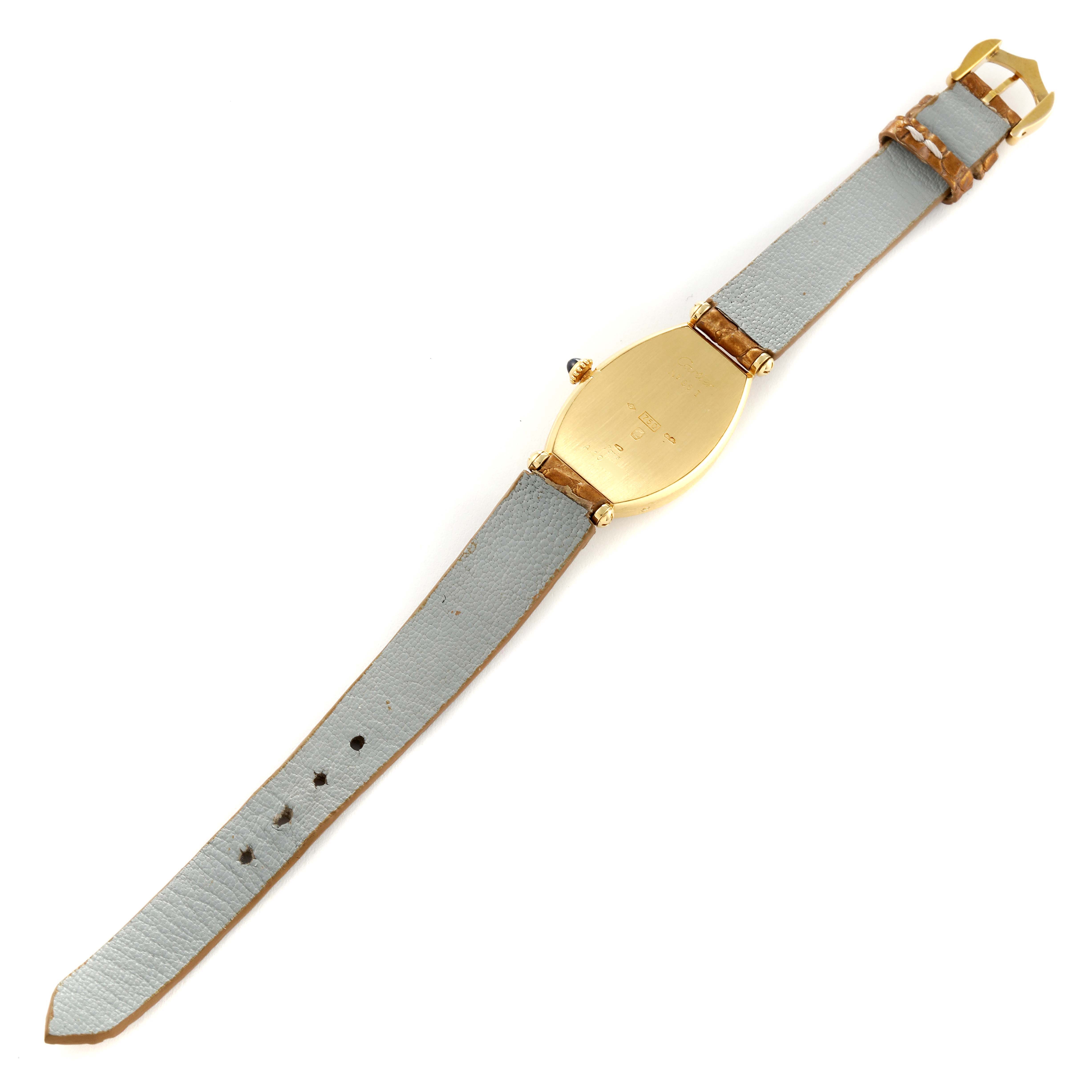 This image shows the back view of a Cartier Tonneau Women's Yellow Gold Silver Dial Women's Yellow Gold Silver Dial watch, highlighting the gold case and gray leather strap.