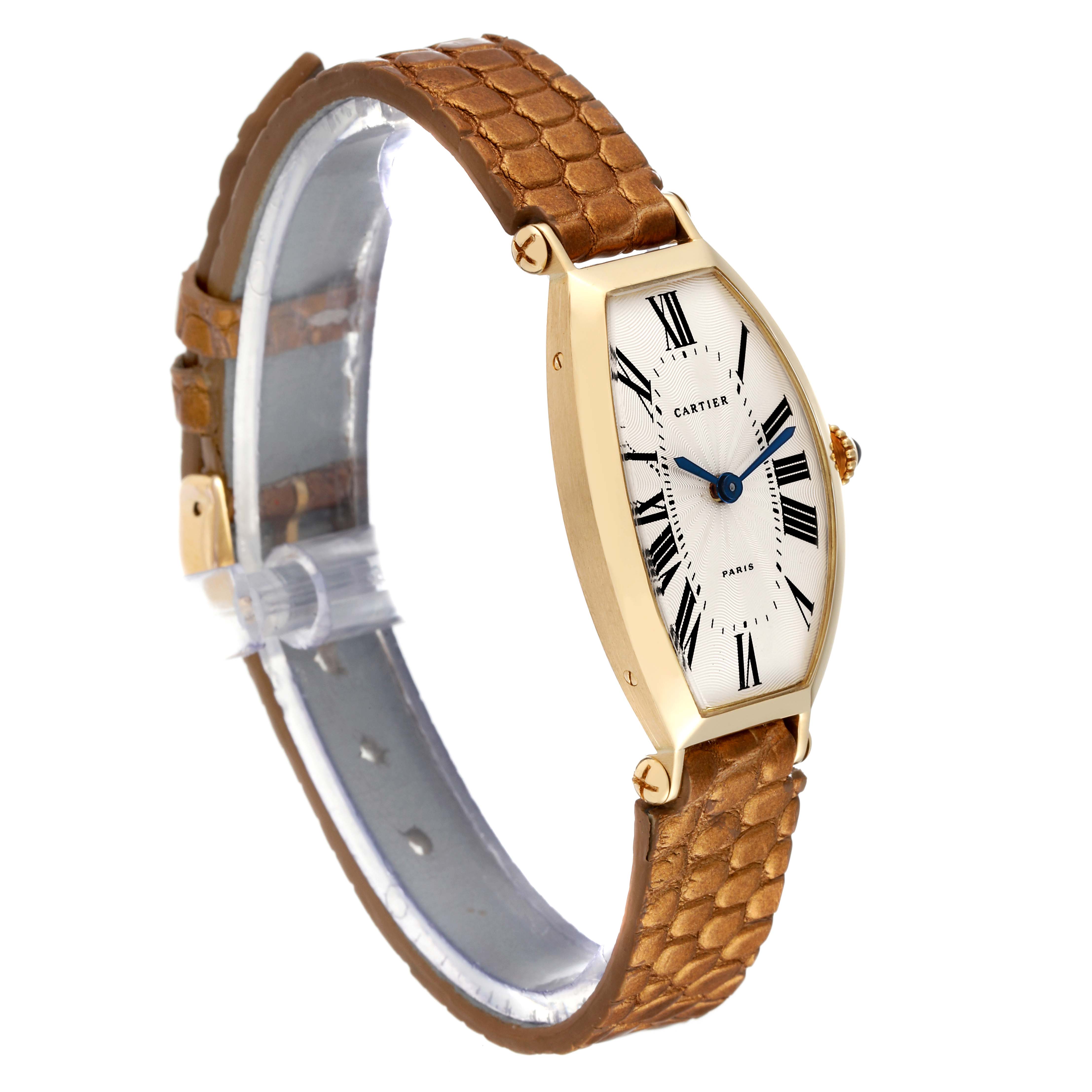 This Tonneau model watch by Cartier is shown at an angled side view, highlighting its face and brown leather strap.