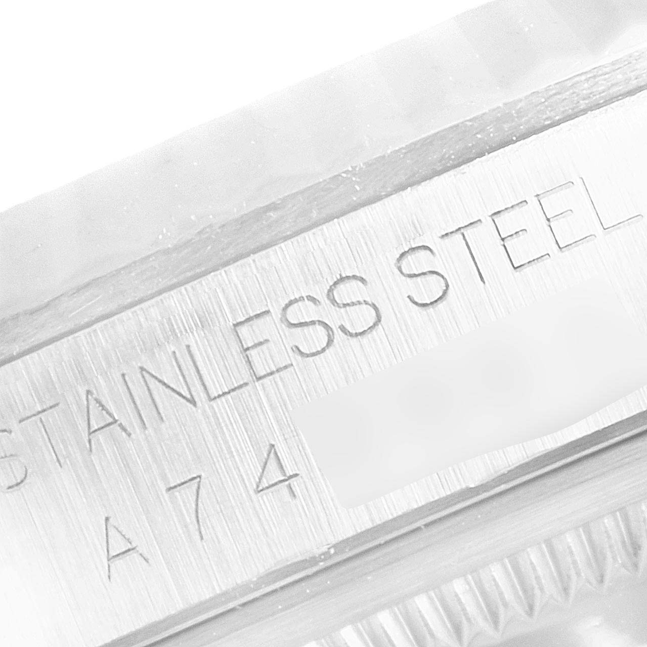 The image shows a close-up of the side engraving and fluted bezel of a Rolex Datejust 16234 Men's Stainless Steel Blue Dial 16234 Men's Stainless Steel Blue Dial watch in stainless steel.