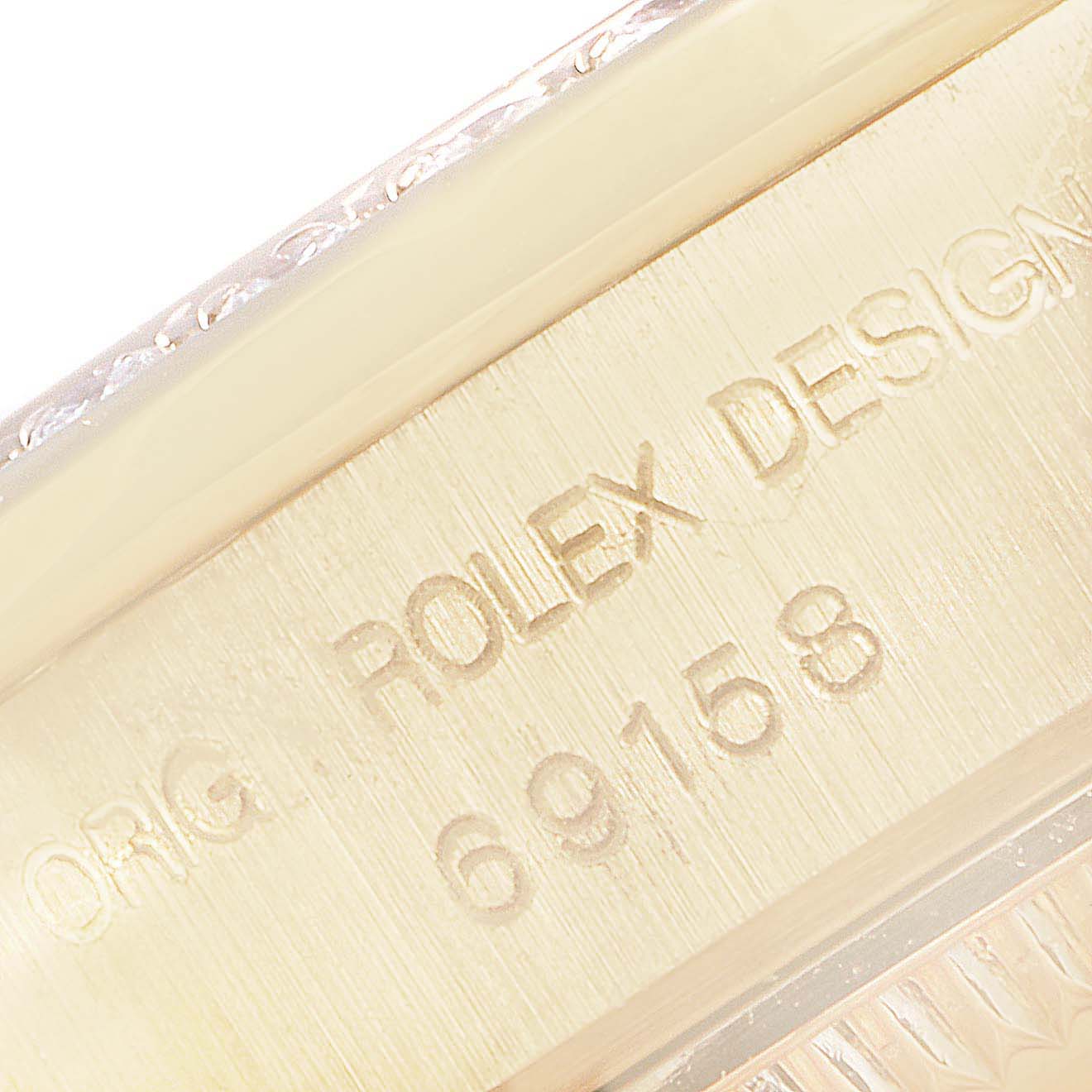 This close-up shows the engraved model number and design inscription on the case of a Rolex President 69158 Women's Yellow Gold Champagne Dial 69158 Women's Yellow Gold Champagne Dial watch.