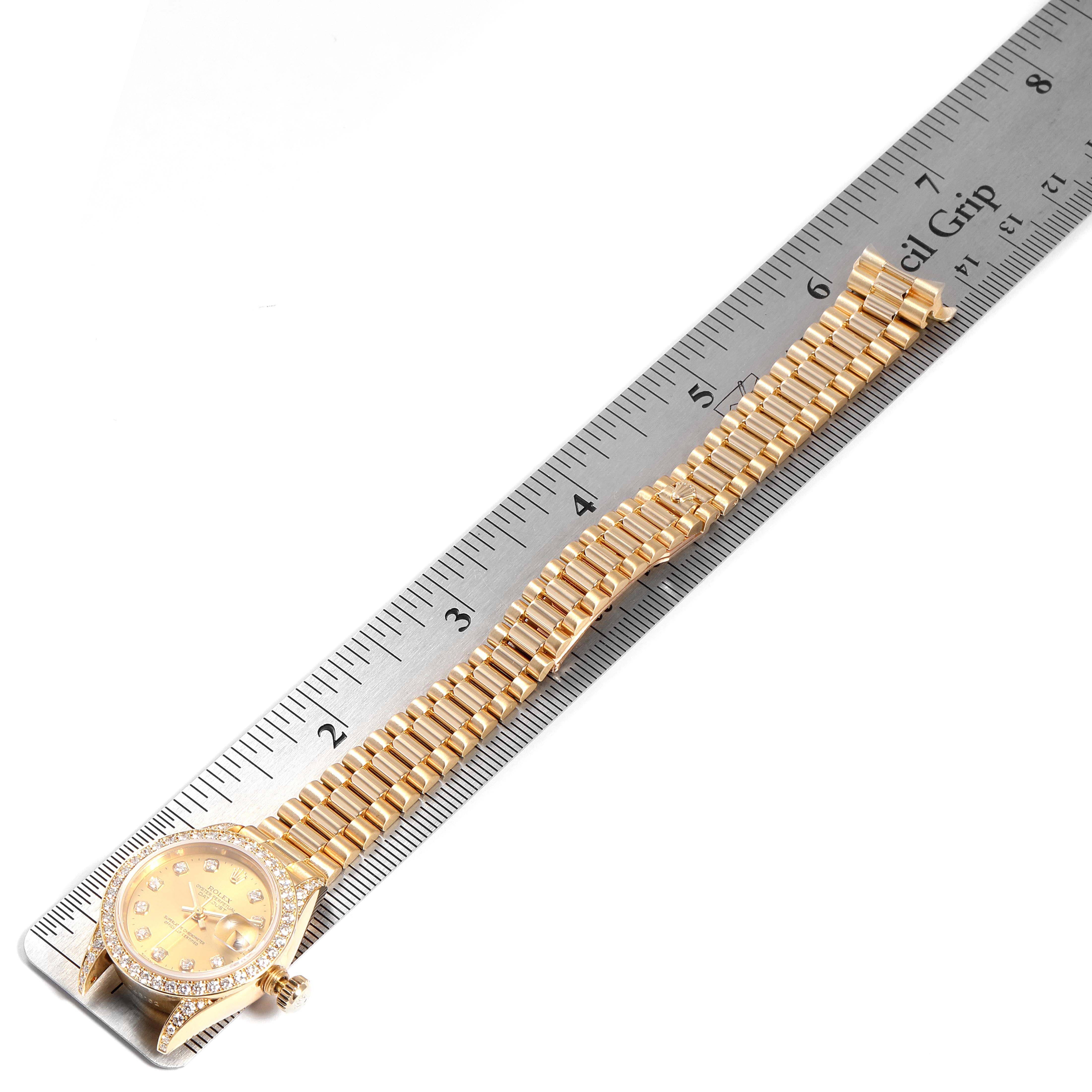 The Rolex President 69158 Women's Yellow Gold Champagne Dial 69158 Women's Yellow Gold Champagne Dial model watch is shown from an angled top view, including the dial and the full bracelet, placed alongside a ruler.
