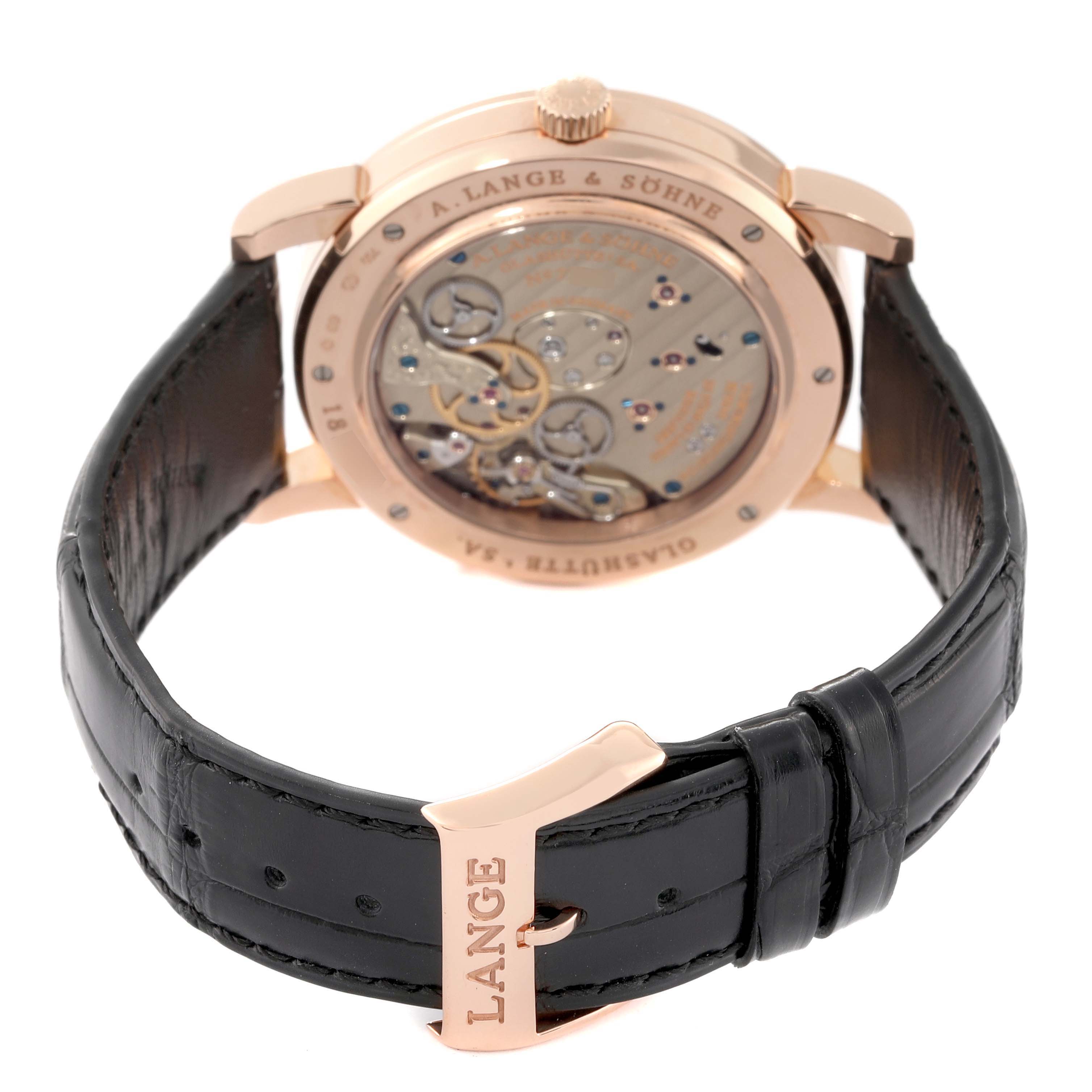 The image shows the back view of the A. Lange & Sohne Lange 1 116.032 Men's Rose Gold Silver Dial watch, highlighting the exposed movement and black leather strap.