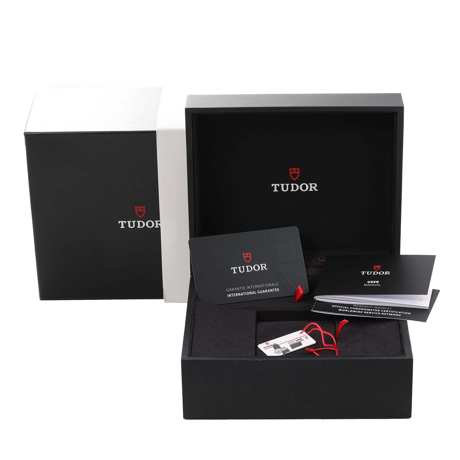 The Tudor Pelagos 25407N Men's Titanium Black Dial 25407N Men's Titanium Black Dial watch accessories include warranty cards, a user manual, and tags in an open presentation box.