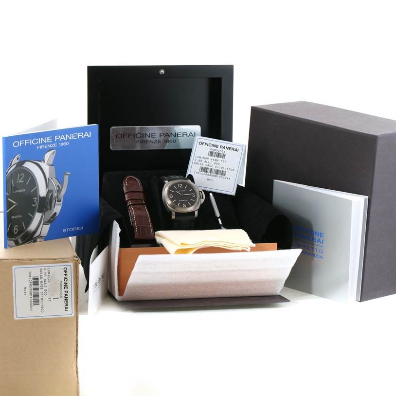 The image shows a Panerai Luminor PAM00055 Men's Titanium Black Dial PAM00055 Men's Titanium Black Dial watch from a front angle, along with its packaging, a brown leather strap, manuals, and an additional tool.